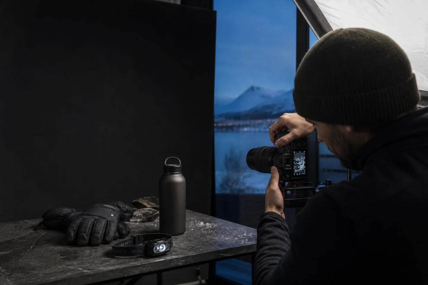 Produktfotograf i Tromsø fotograferer friluftsutstyr i et studio ved fjorden